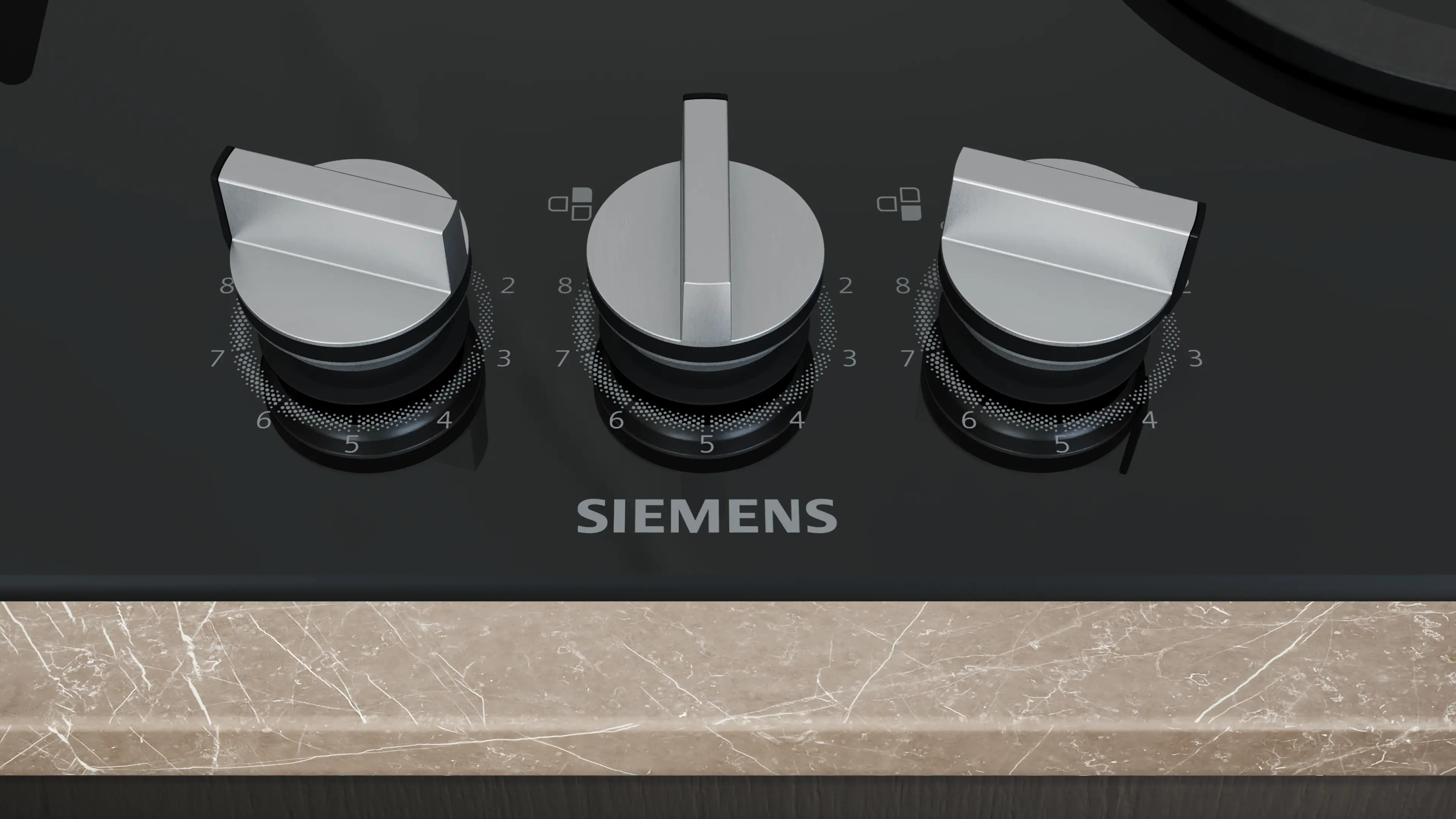 Tres mandos plateados en una encimera negra Siemens con encimera de mármol.