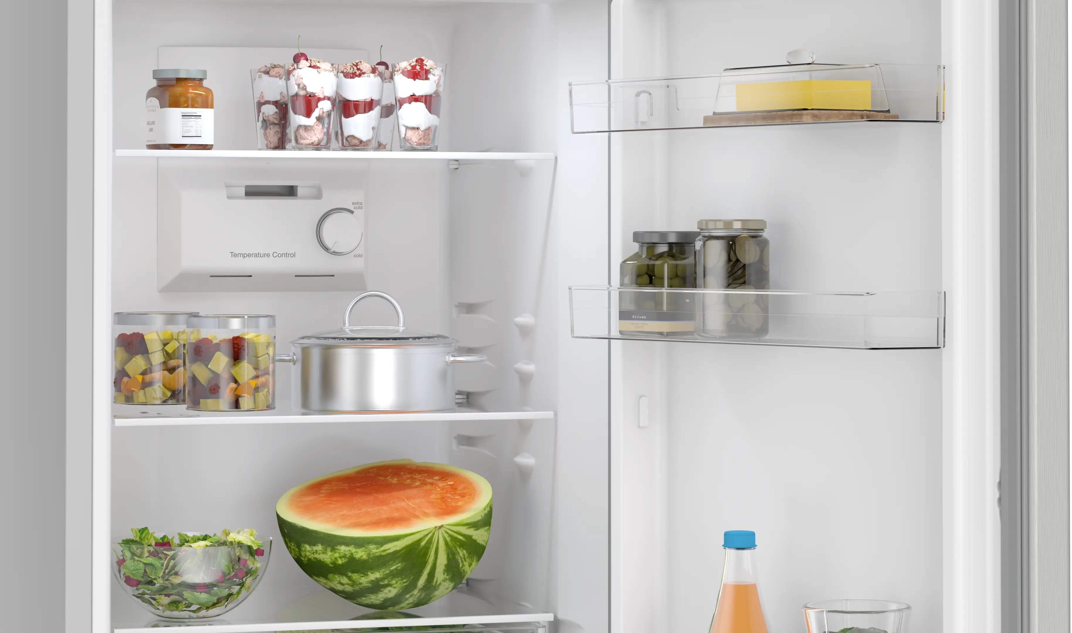 Un refrigerador blanco lleno de comida que incluye postres, ollas, media sandía y frascos.