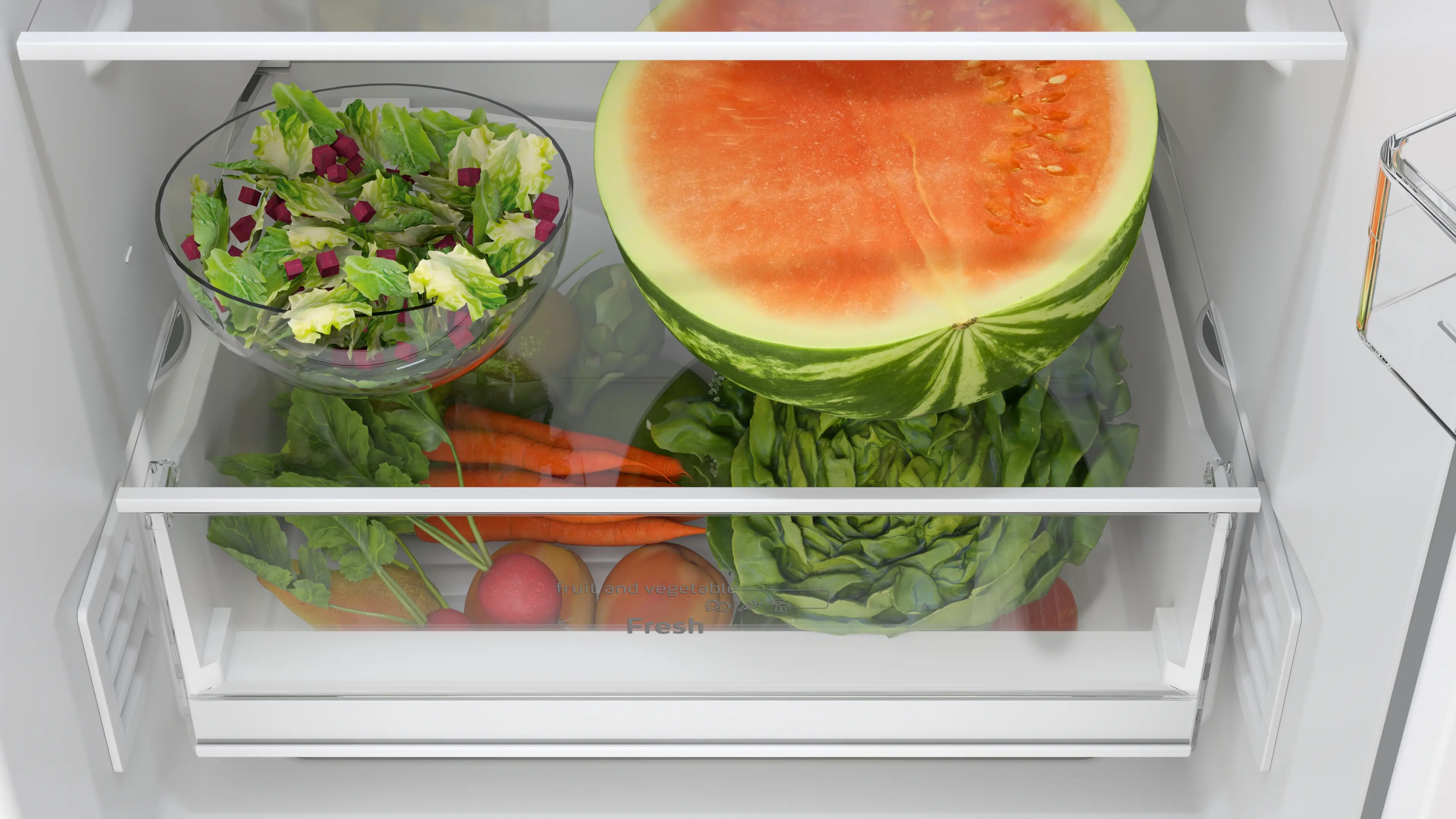 Un refrigerador abierto con un tazón de ensalada, media sandía grande y verduras frescas en el cajón.