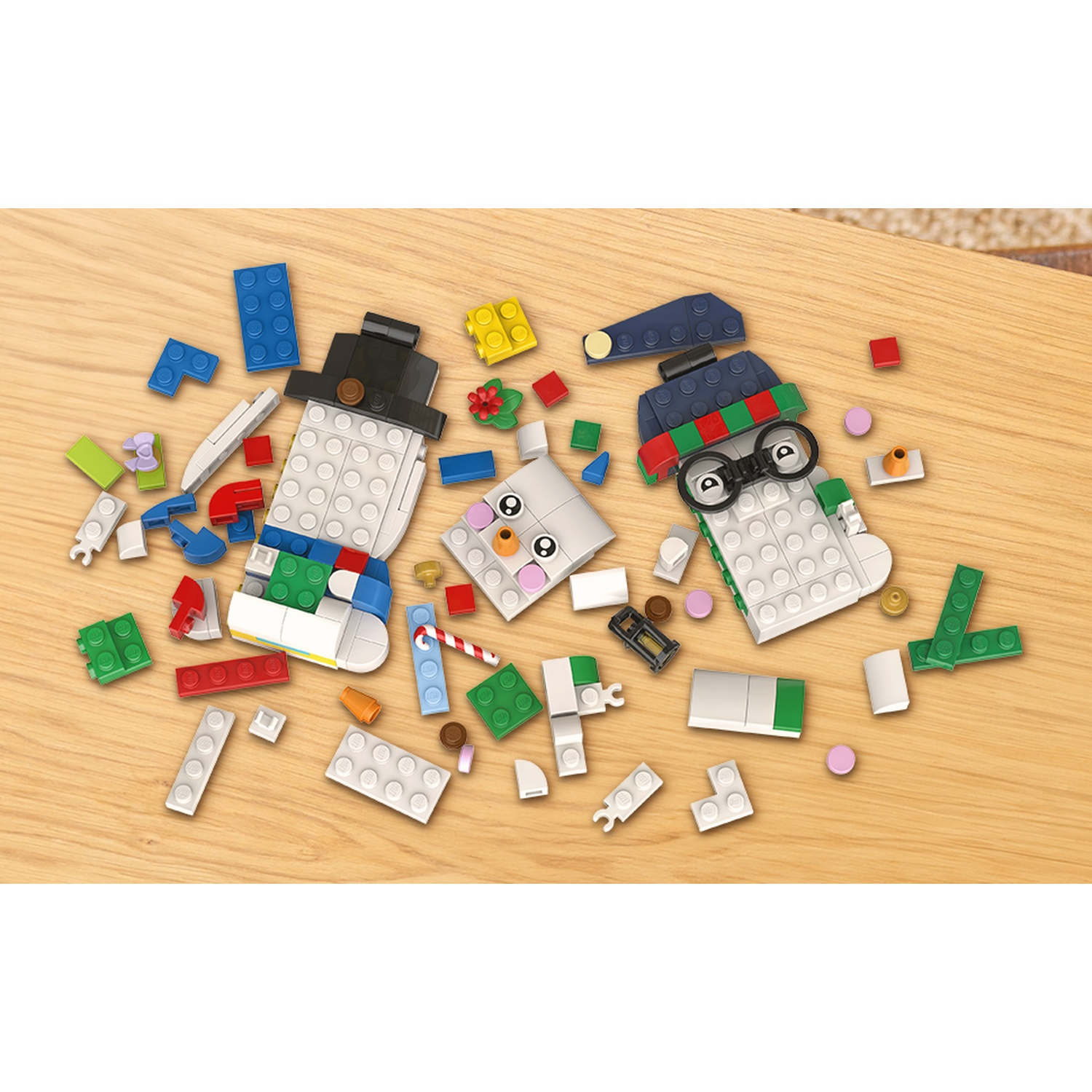 Vari mattoncini LEGO colorati sono sparsi su una superficie di legno chiaro.