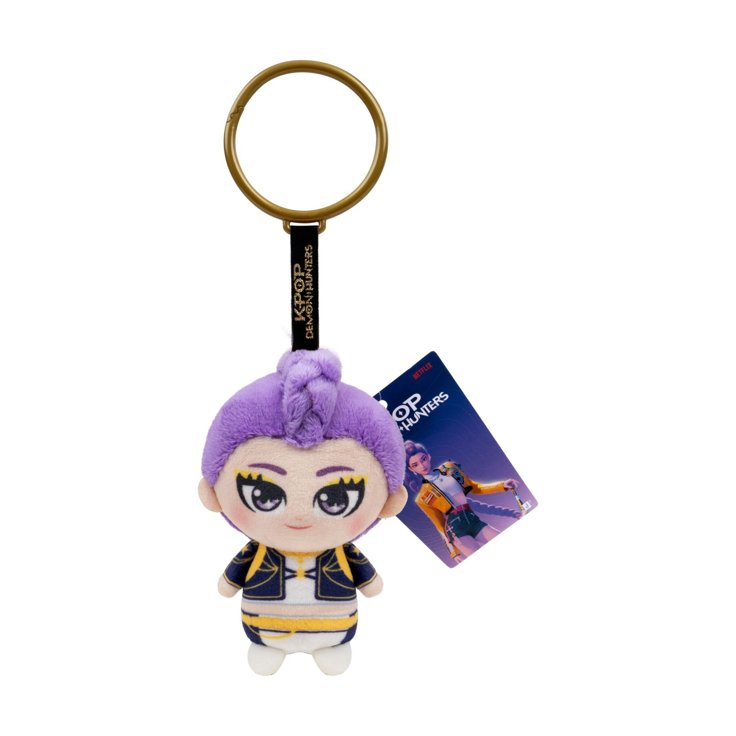 Portachiavi in peluche con capelli viola, anello dorato, nastro nero e etichetta K-Pop: Demon Hunters su sfondo bianco.