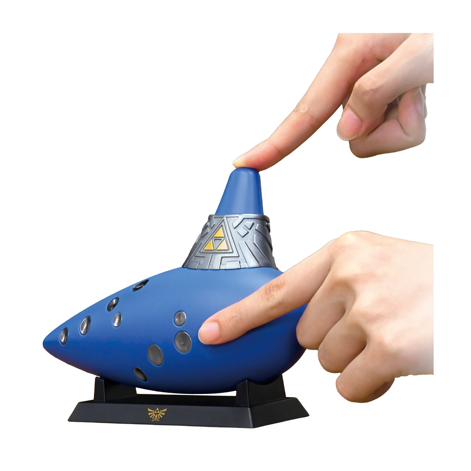 Mani premono i pulsanti su un'ocarina blu su un supporto.