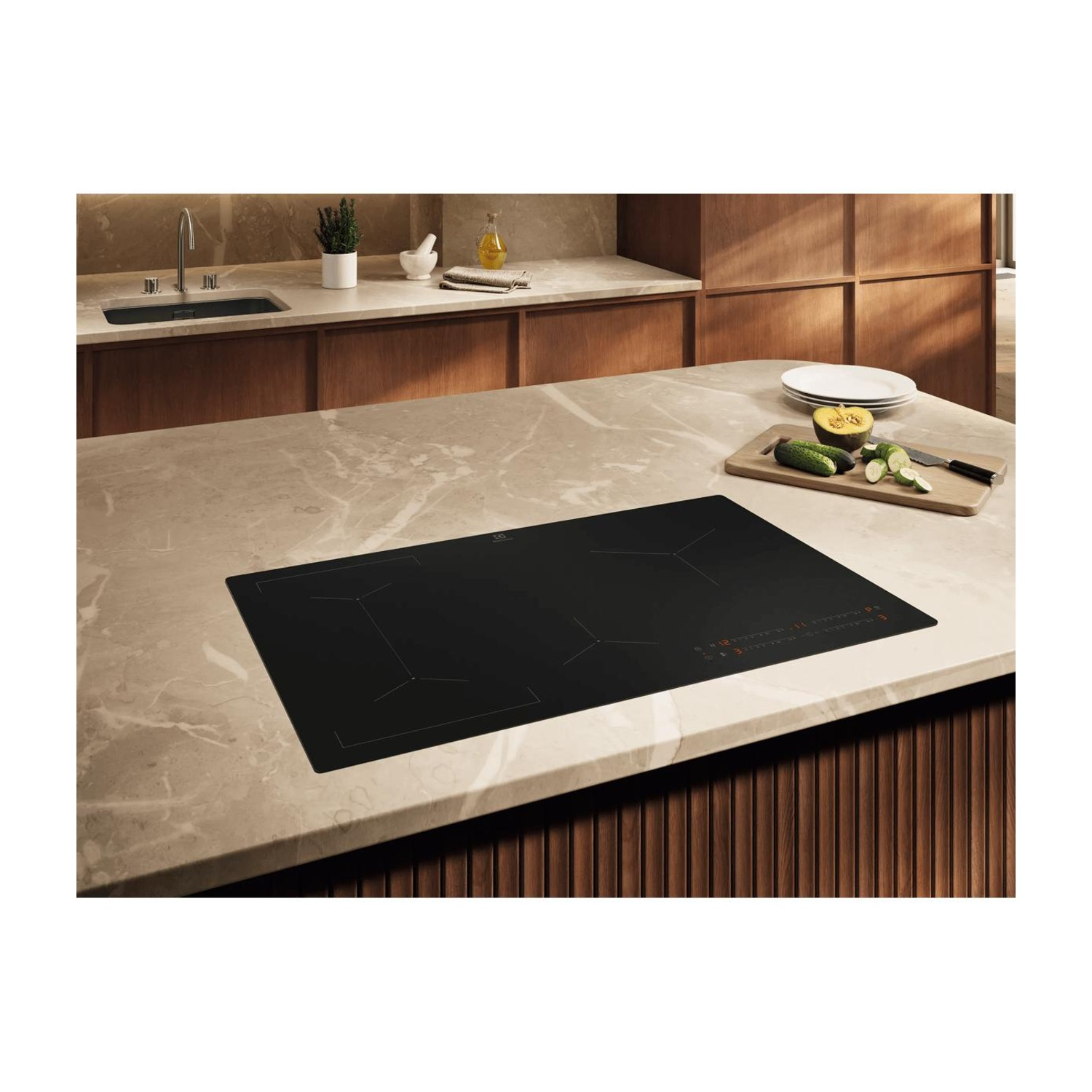Moderno piano cottura a induzione nero su piano in marmo in cucina di legno.