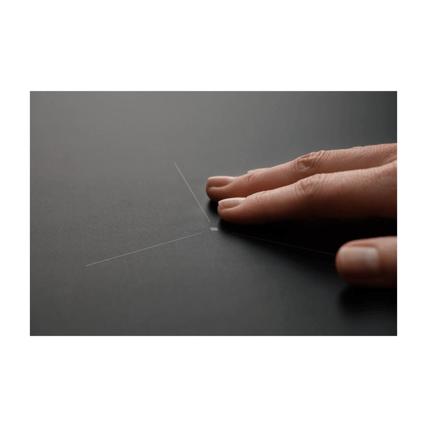 Una mano tocca una superficie nera e liscia segnata da linee sottili e chiare.