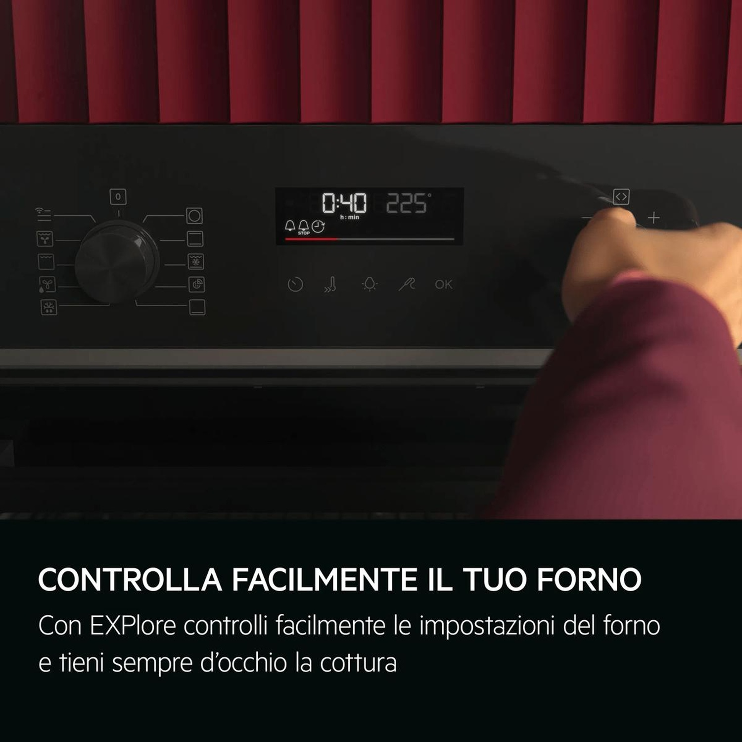 Una mano regola il pannello di controllo digitale di un forno nero con pannelli rossi.