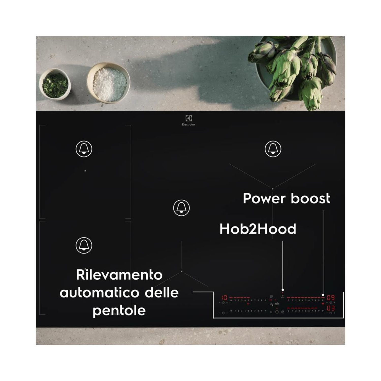 Piano cottura a induzione nero con Power boost, Hob2Hood e rilevamento pentole, circondato da ingredienti.