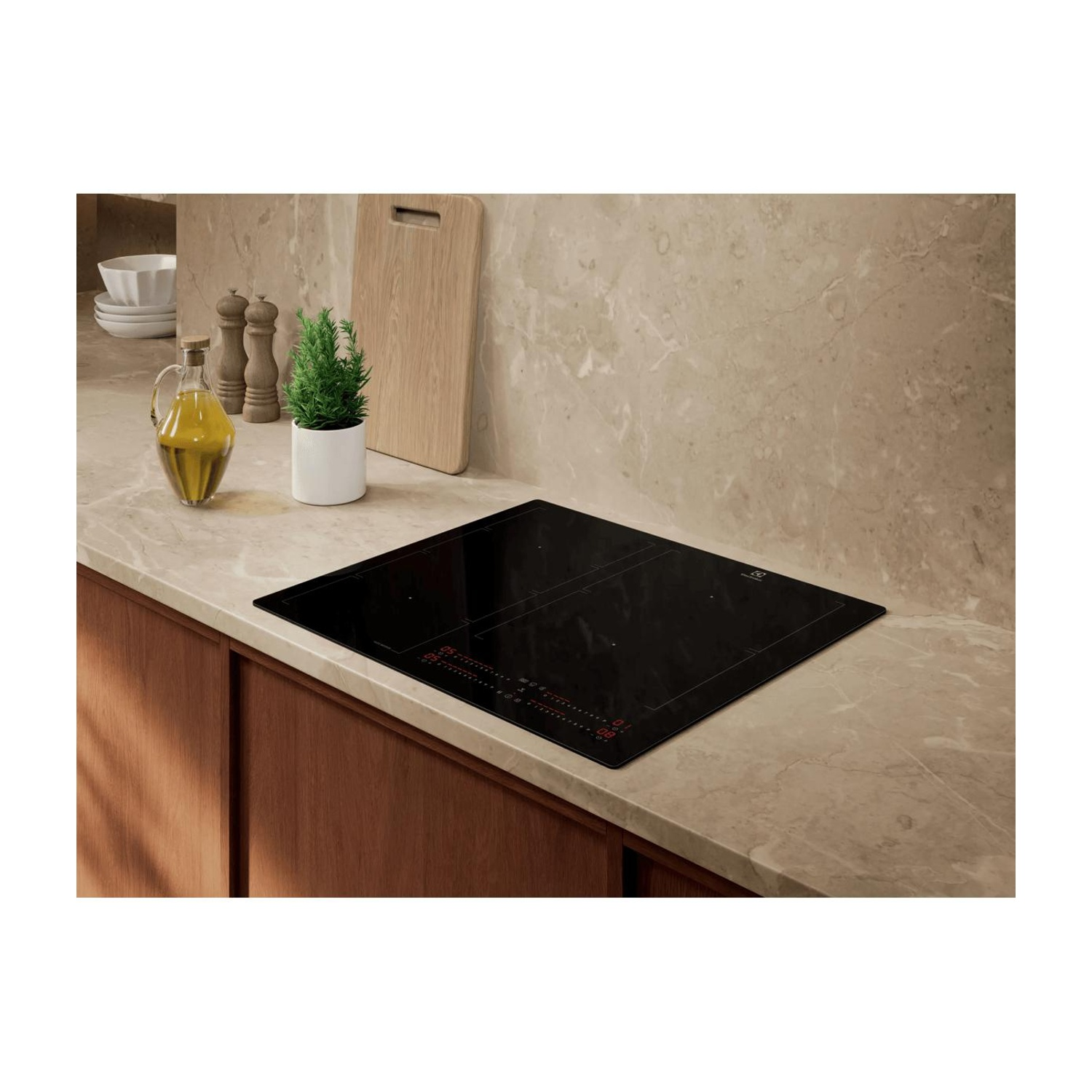 Un piano cottura a induzione nero su un bancone in una cucina moderna con olio d'oliva e piante.