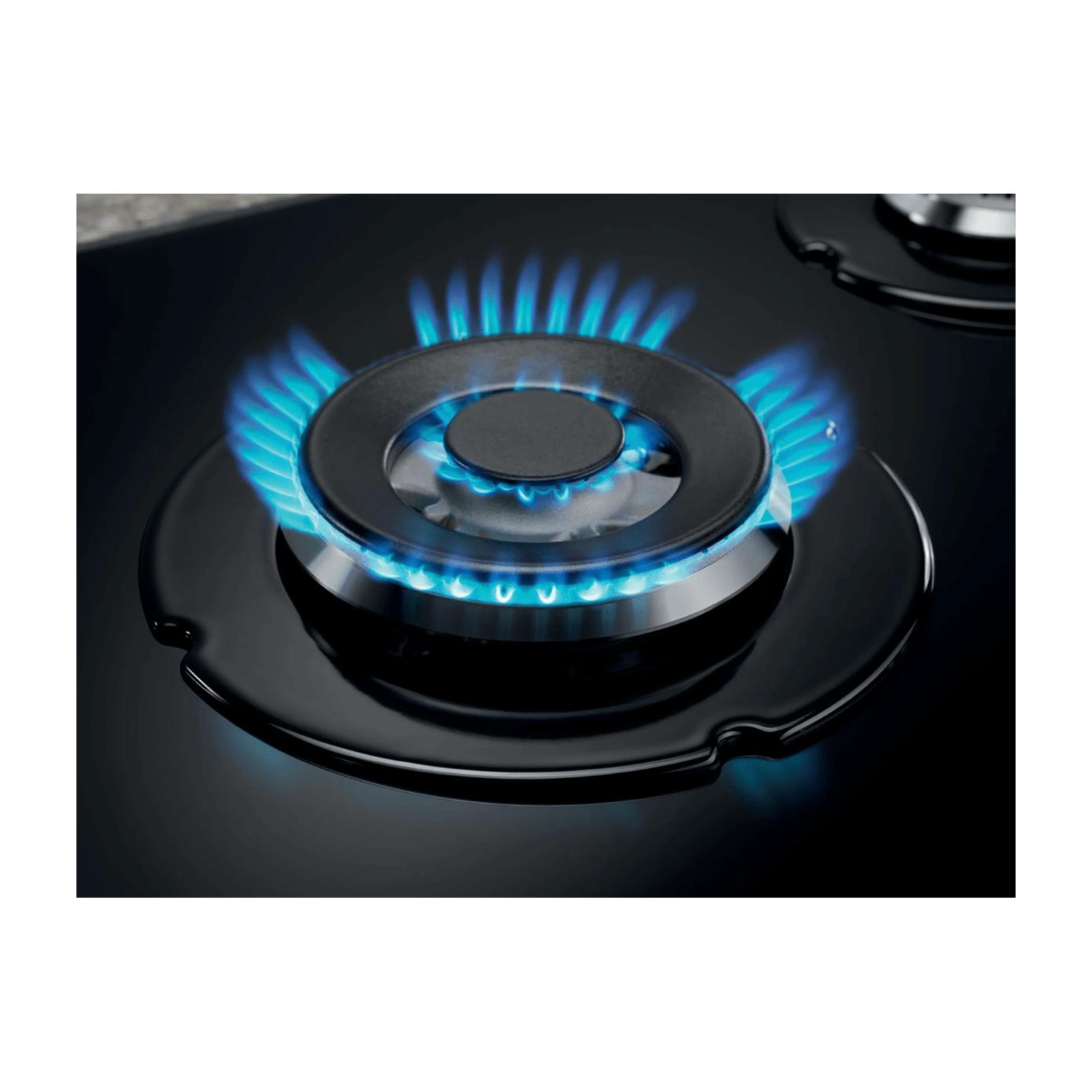 Un bruciatore a gas nero con fiamme blu brillanti su una superficie scura.