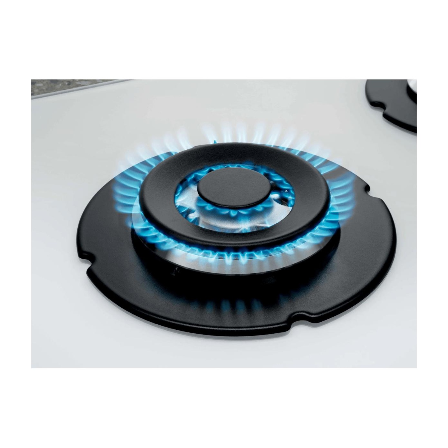 Un bruciatore a gas rotondo su un piano cottura bianco con fiamme blu.
