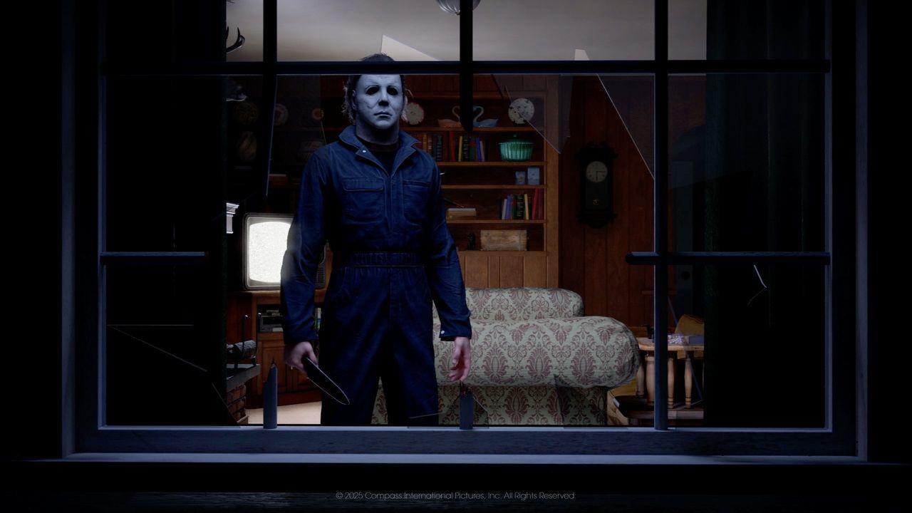 Michael Myers in dunklem Overall und weißer Maske steht mit Messer in einem beleuchteten Raum hinter einem Fenster.