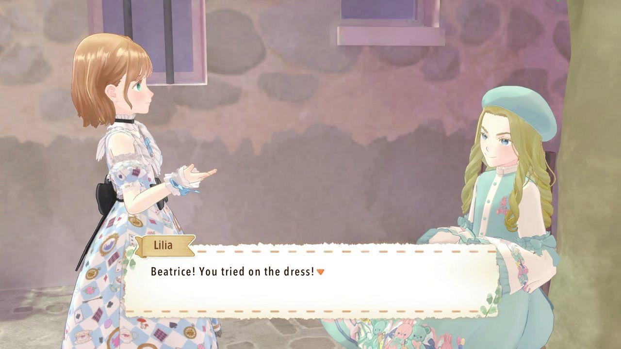 Lilia spricht mit Beatrice vor einem Steinhaus und sagt: Beatrice! Du hast das Kleid anprobiert!