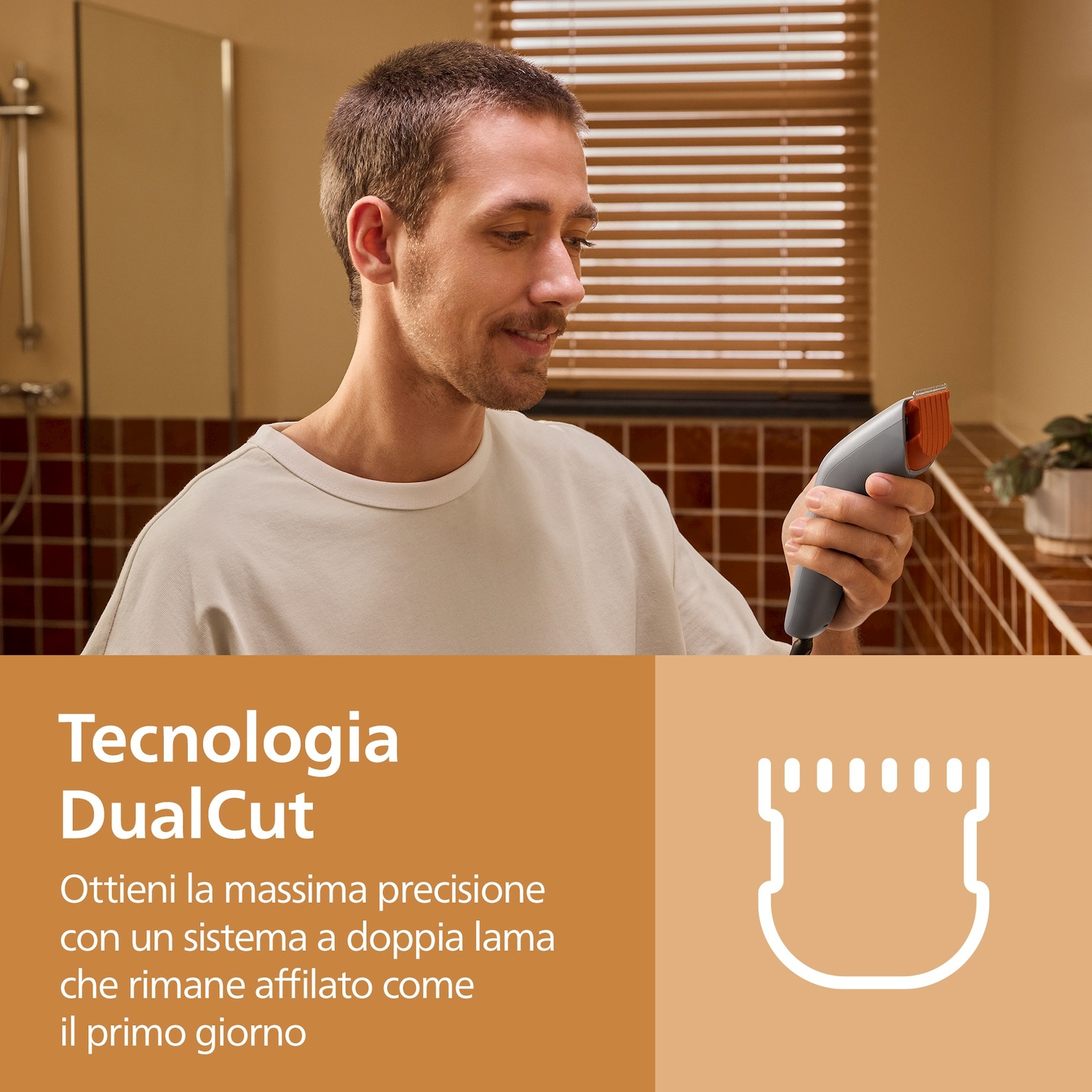 Un uomo con camicia bianca tiene un tagliacapelli grigio in bagno, con testo sulla tecnologia DualCut.