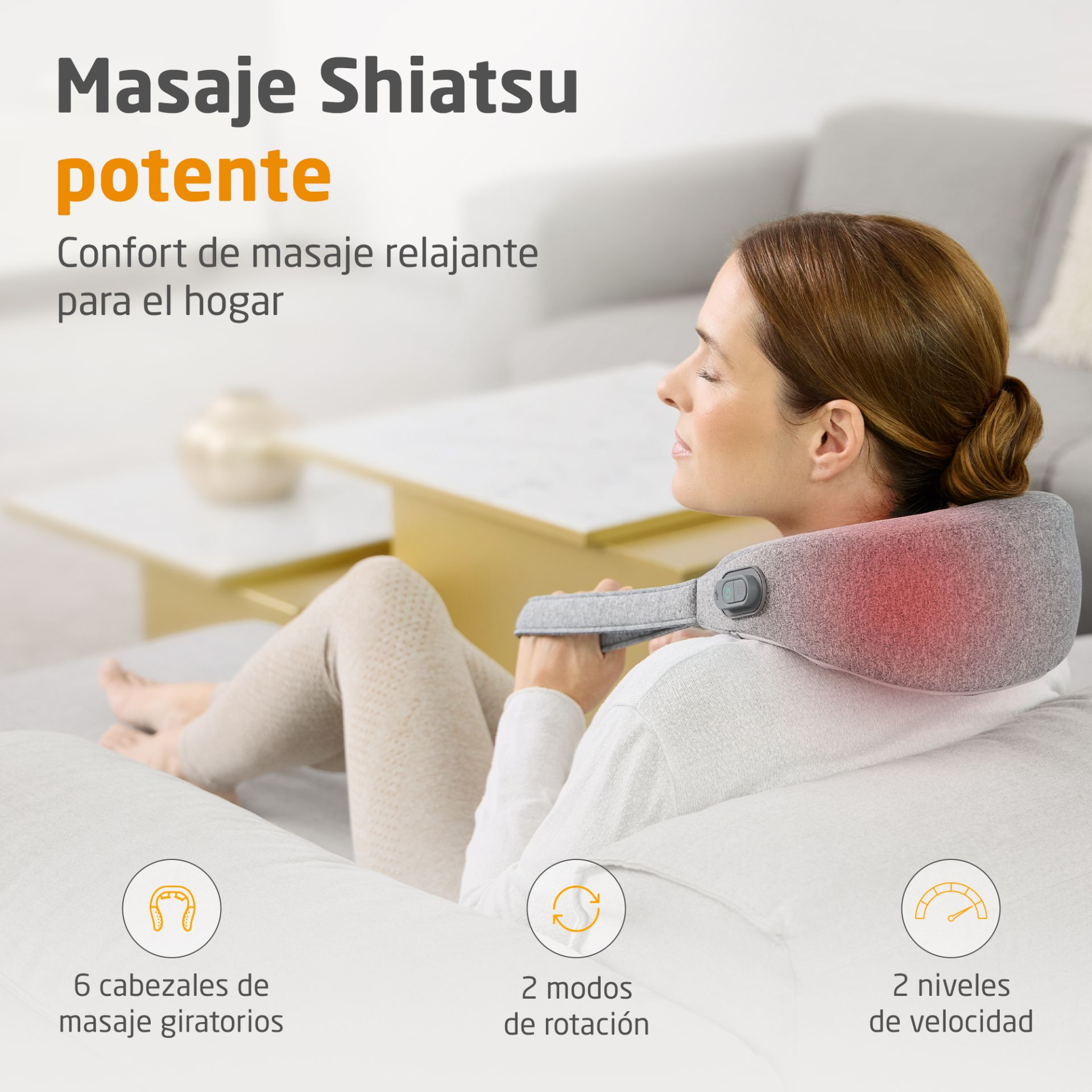 Una mujer se relaja en un sofá usando un masajeador de cuello Shiatsu gris.