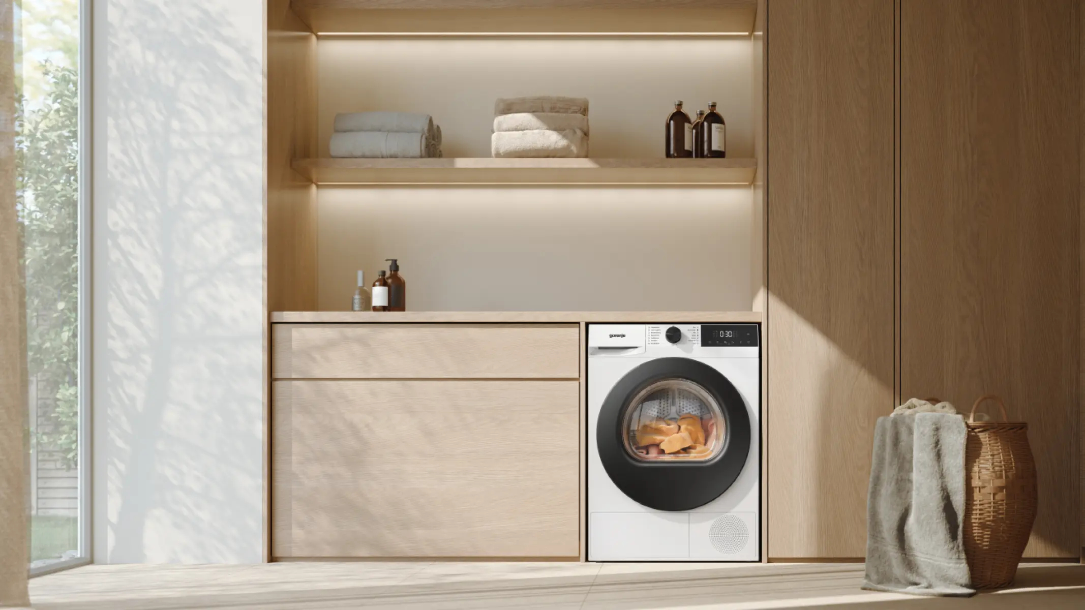 Moderne Waschmaschine in Holzregal mit Handtüchern und Korb.