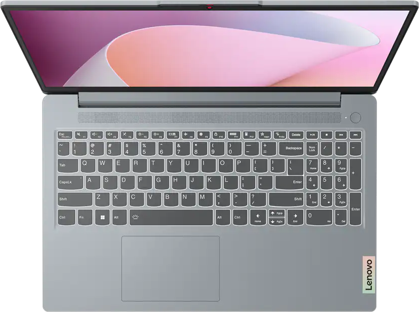 Felülnézet egy nyitott szürke laptopról megvilágított billentyűzettel és rózsaszín háttérképpel.