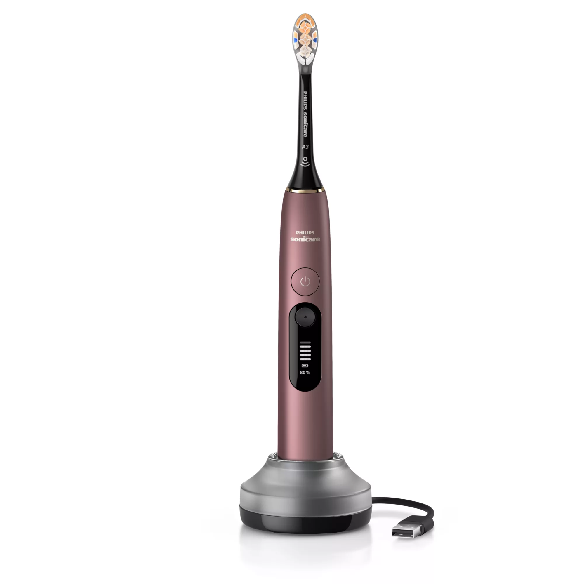 Różowa szczoteczka elektryczna Philips Sonicare na srebrnej podstawie ładującej z kablem USB.