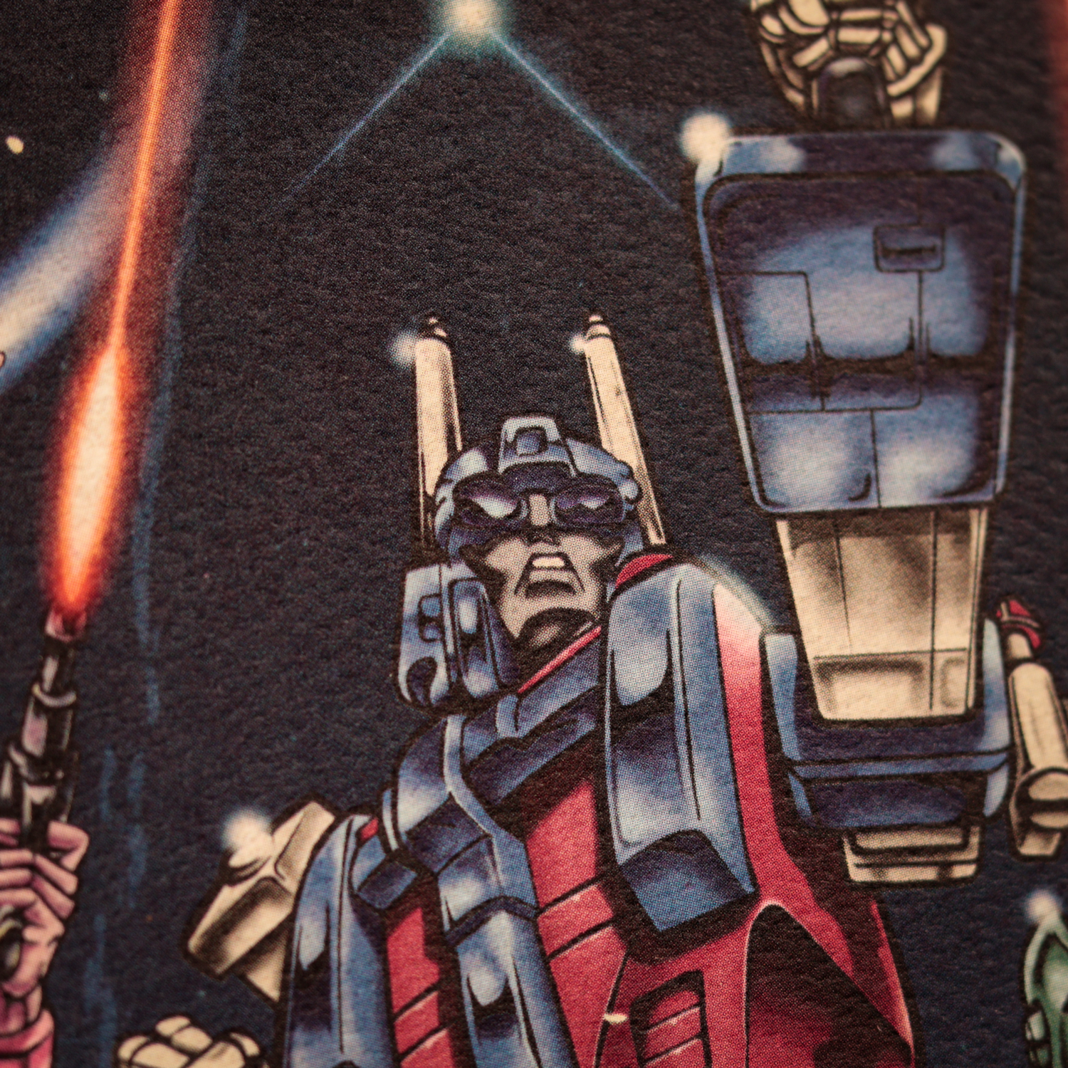 Ilustración en cómic de Optimus Prime sosteniendo un bláster en el espacio con un fondo estrellado y un rayo láser.