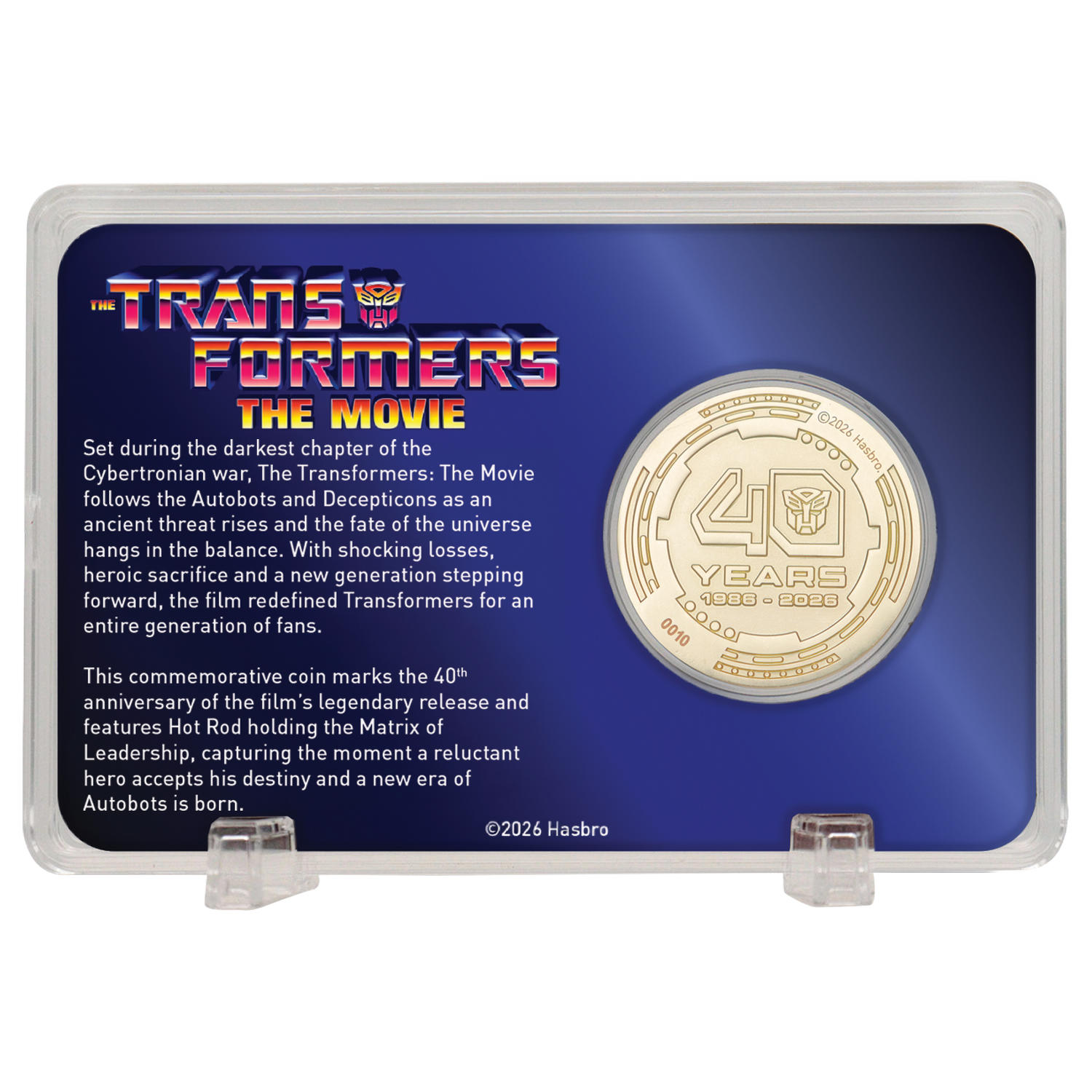 Una moneda conmemorativa del 40 aniversario de Transformers en un soporte acrílico con texto.
