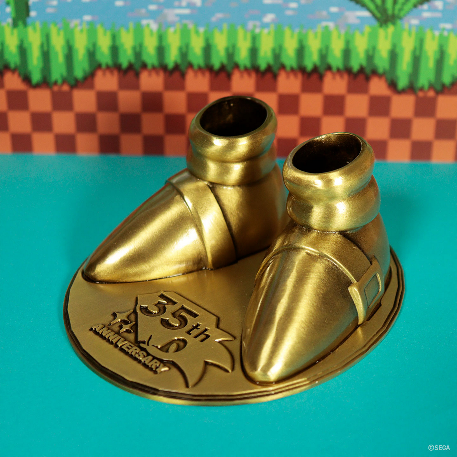 Zapatos dorados en una base del 35 aniversario con fondo de videojuego.