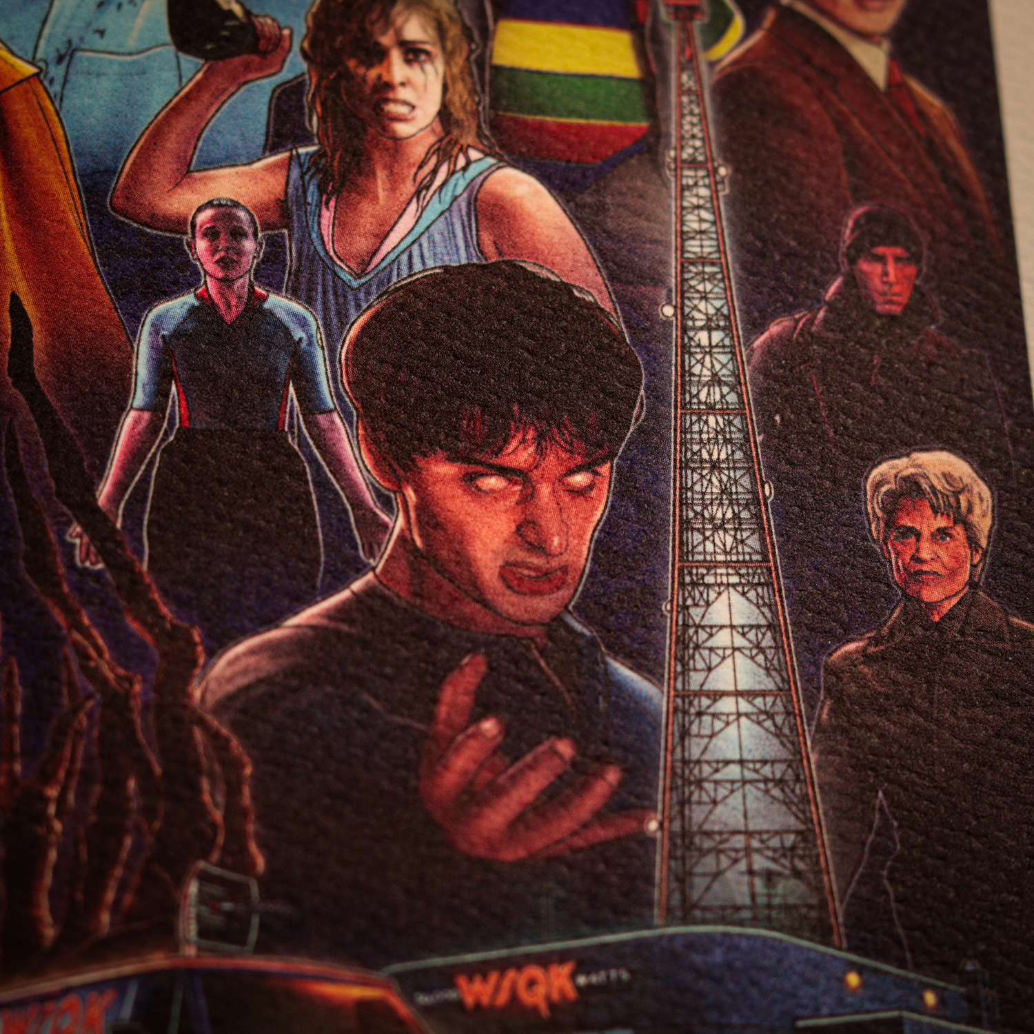 Un póster de Stranger Things con personajes, una torre de radio y un ambiente oscuro.
