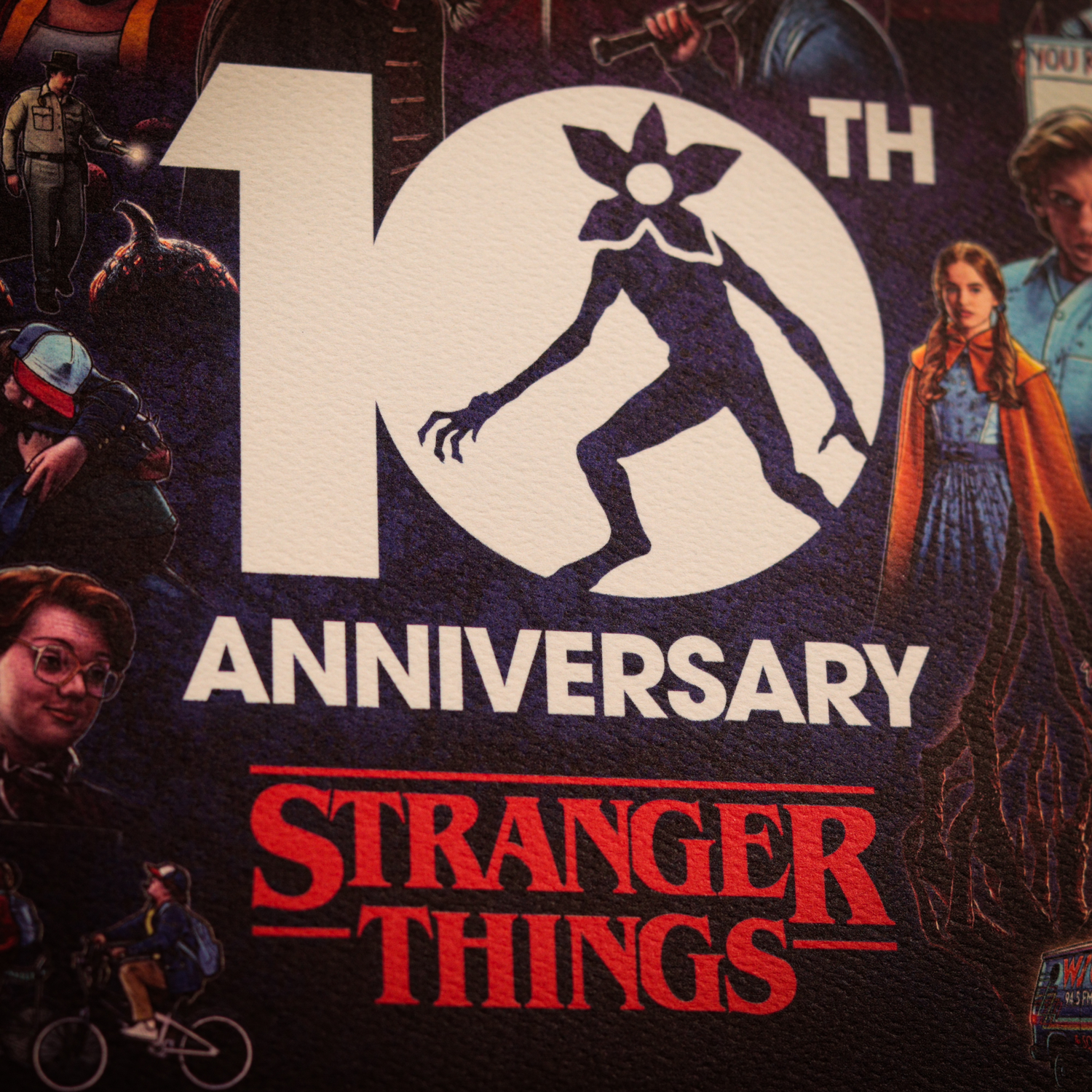 Logotipo del 10.° aniversario de Stranger Things con silueta de Demogorgon y personajes.