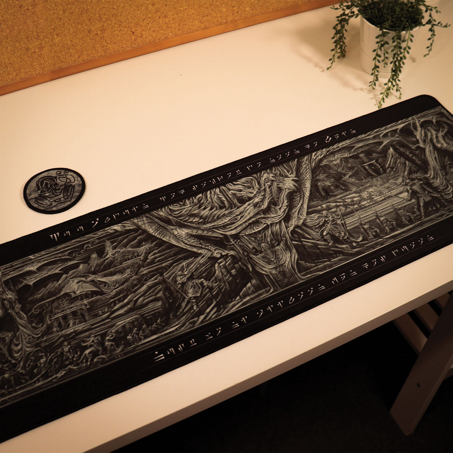 Alfombrilla de escritorio negra con arte de fantasía detallado, posavasos redondo y planta en una mesa blanca.