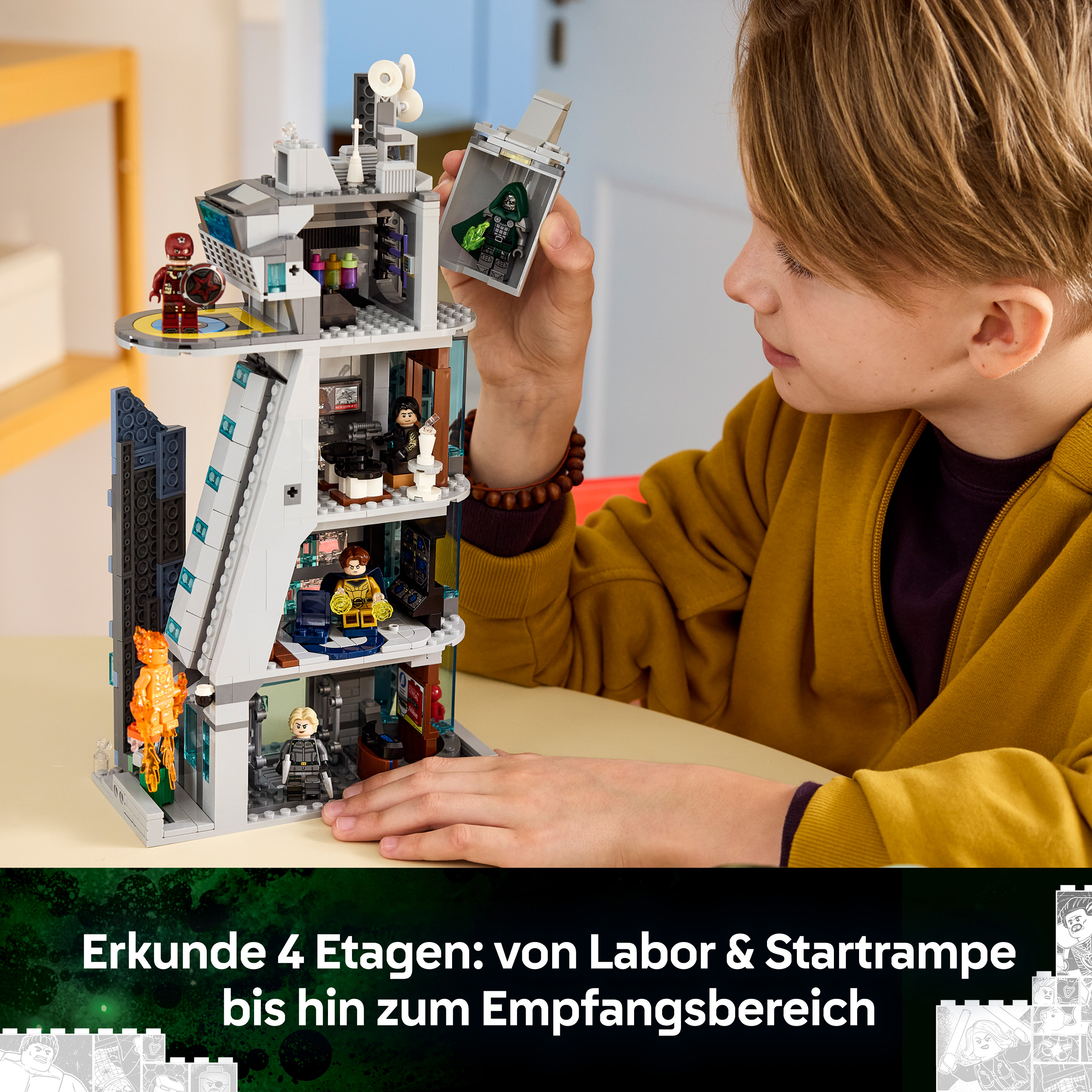 Ein Junge spielt mit einem mehrstöckigen Lego-Turm mit verschiedenen Räumen.