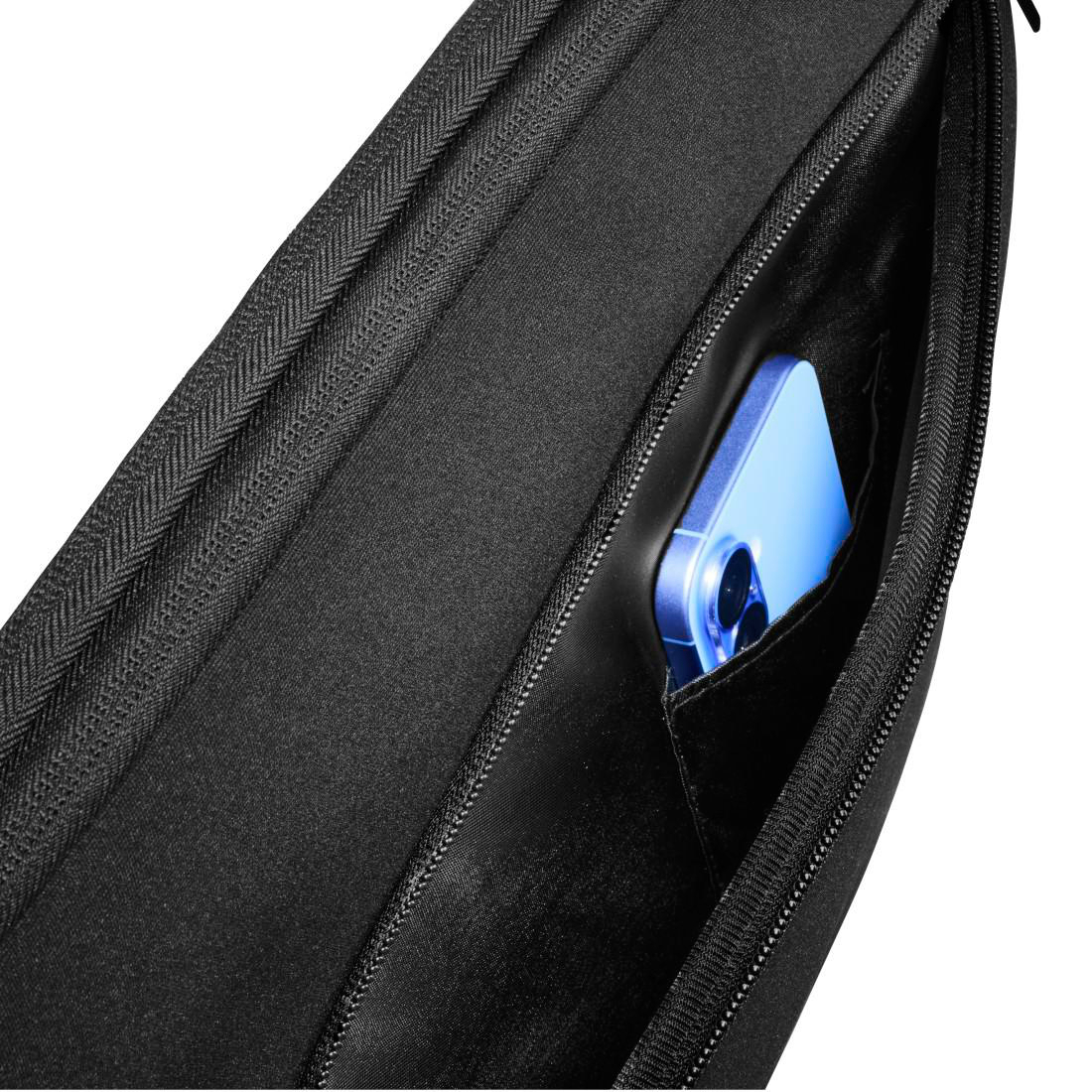 Ein blaues Smartphone steckt in der schwarzen Tasche einer schwarzen Tasche vor weißem Hintergrund.