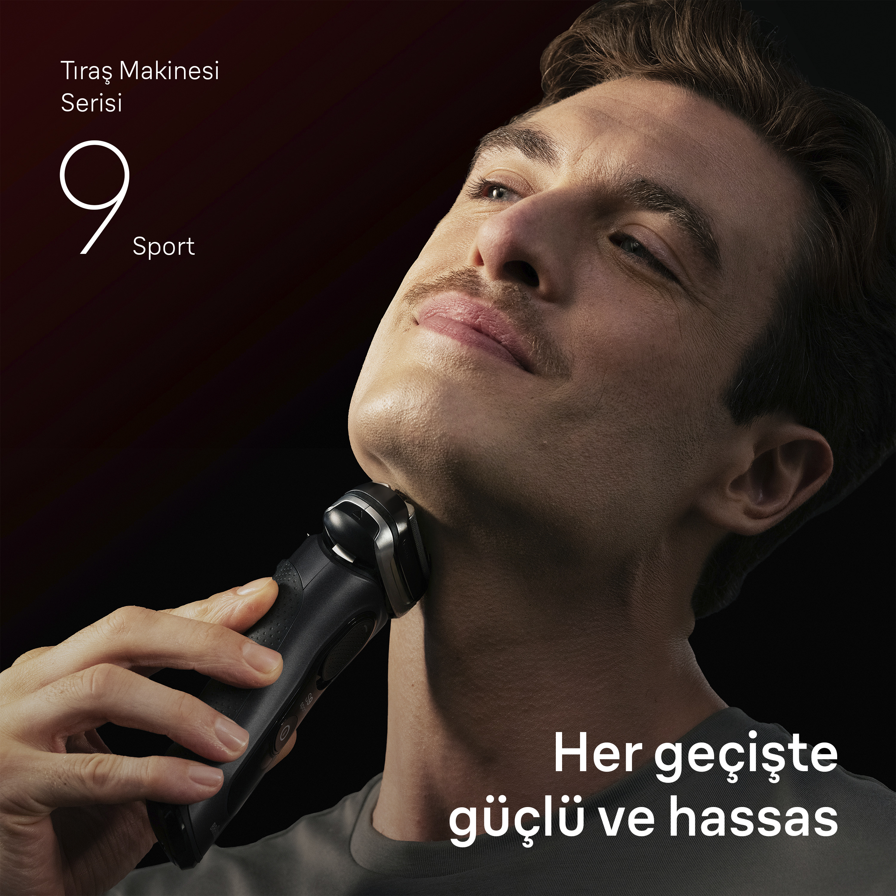Bir erkek çenesini siyah elektrikli tıraş makinesiyle tıraş ediyor.