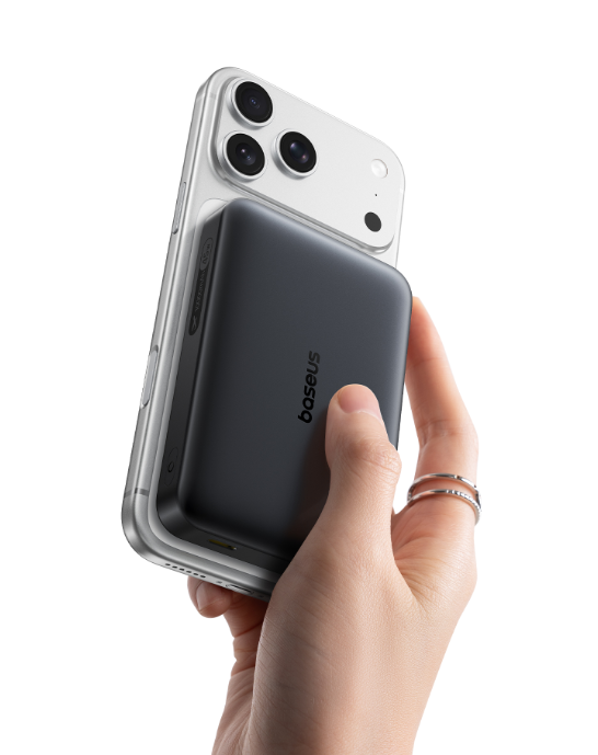 Bir el, arkasında siyah bir Baseus powerbank bulunan gümüş rengi bir akıllı telefonu tutuyor.