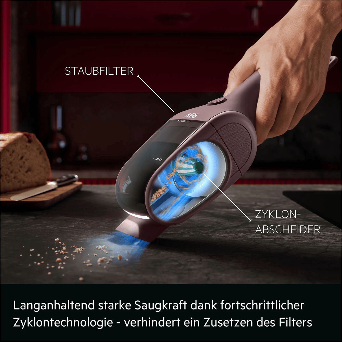 Handstaubsauger mit Zyklontechnologie saugt Krümel von der Arbeitsplatte, mit Erklärungen für Filter und Zyklon.