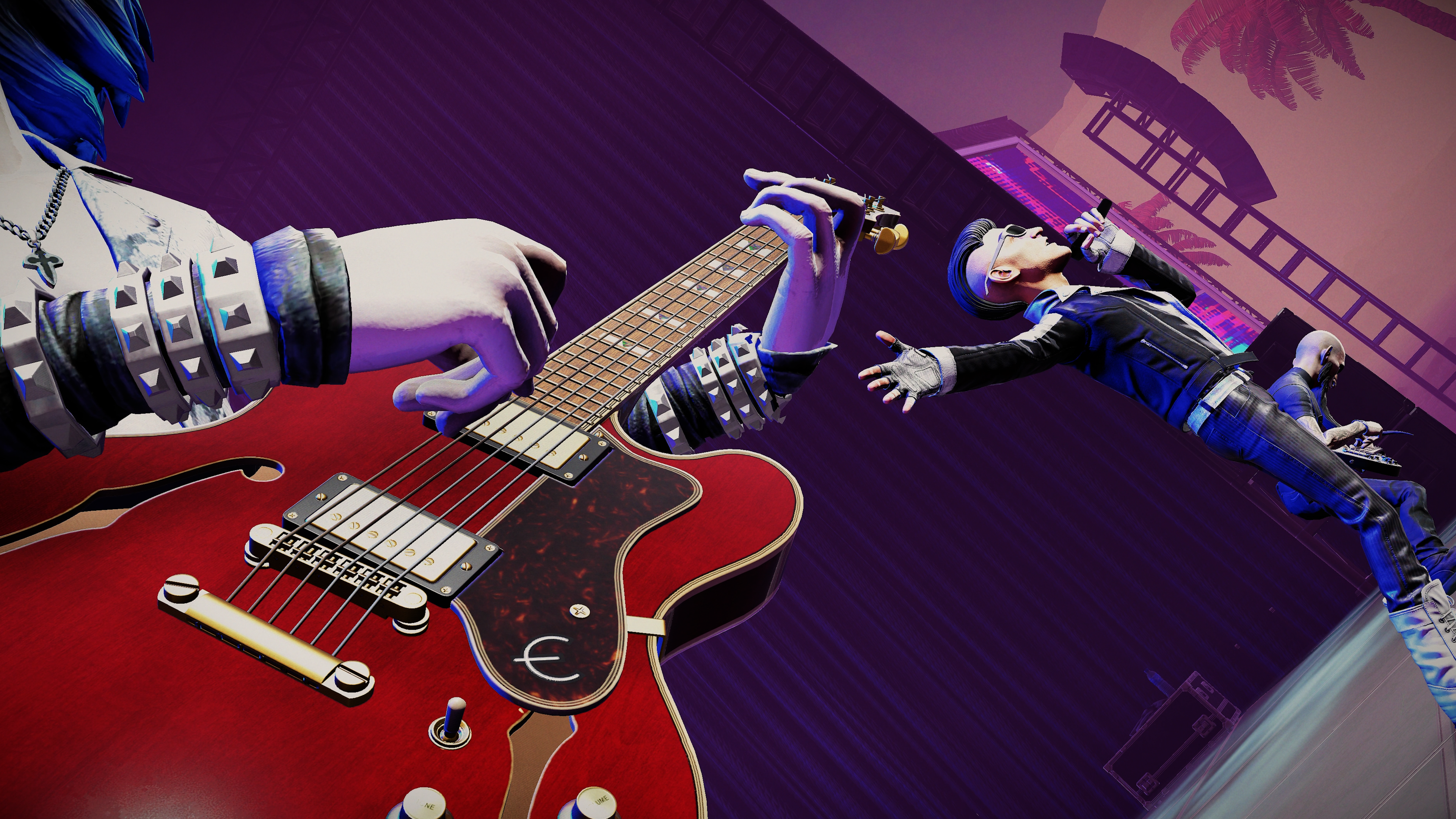 Eine Band spielt auf einer lilafarbenen Bühne, im Vordergrund greift eine Hand in eine rote E-Gitarre.