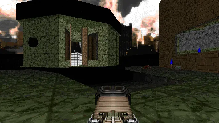 Ich-Perspektive in einem Retro-Videospiel mit einer Waffe im Vordergrund und einem Steingebäude unter dunklem Himmel.