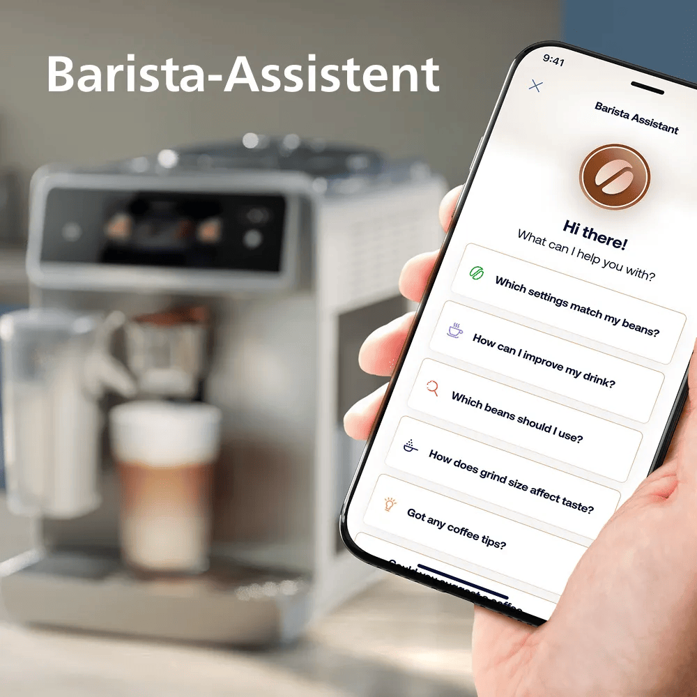 Hand hält Smartphone mit Barista-Assistent-App vor einer Kaffeemaschine.