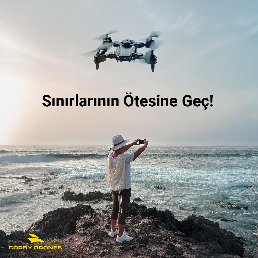 Kayalık sahilinde duran biri, deniz üzerinde uçan bir drone'un fotoğrafını çekiyor.