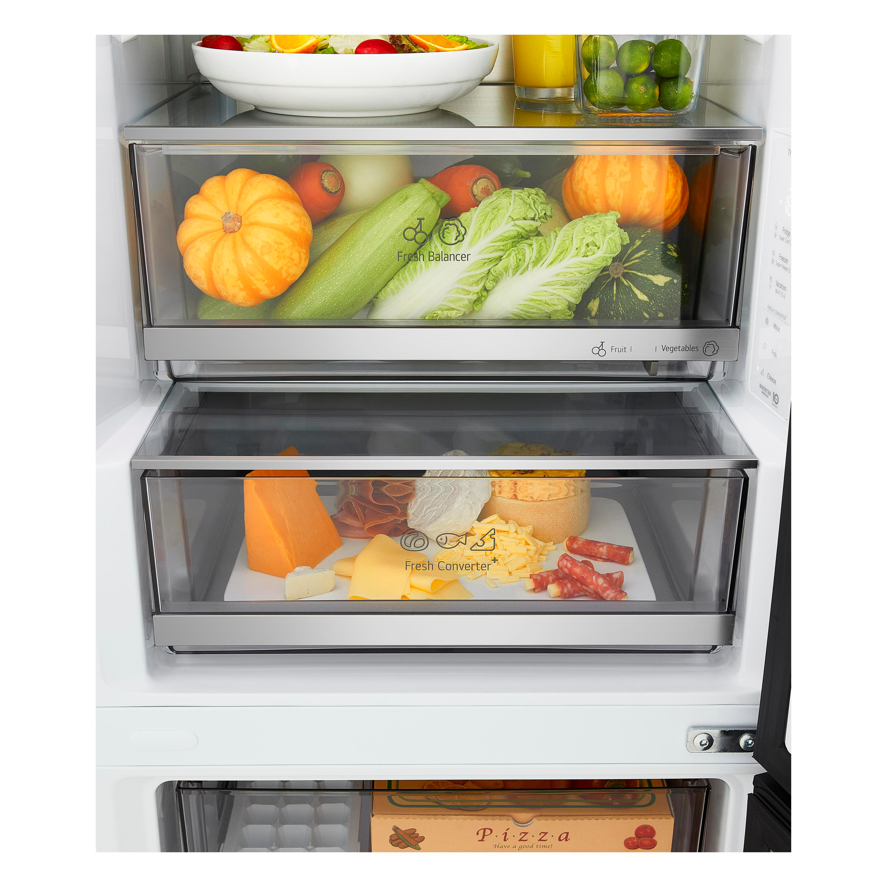 Offener Kühlschrank mit frischem Gemüse im oberen Fach und Käse und Wurst im unteren.