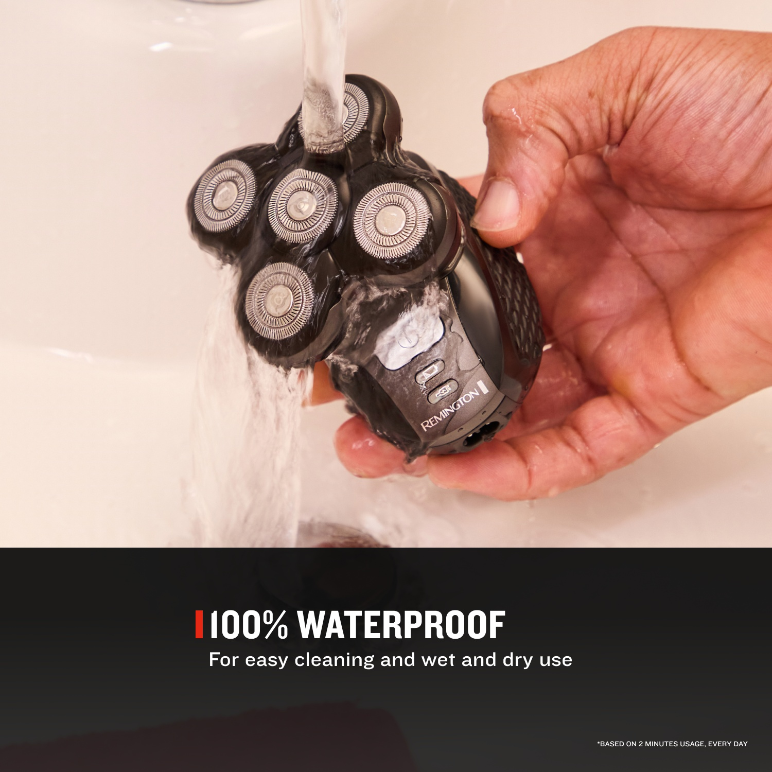 Hand houdt een zwarte Remington scheerapparat onder stromend water.