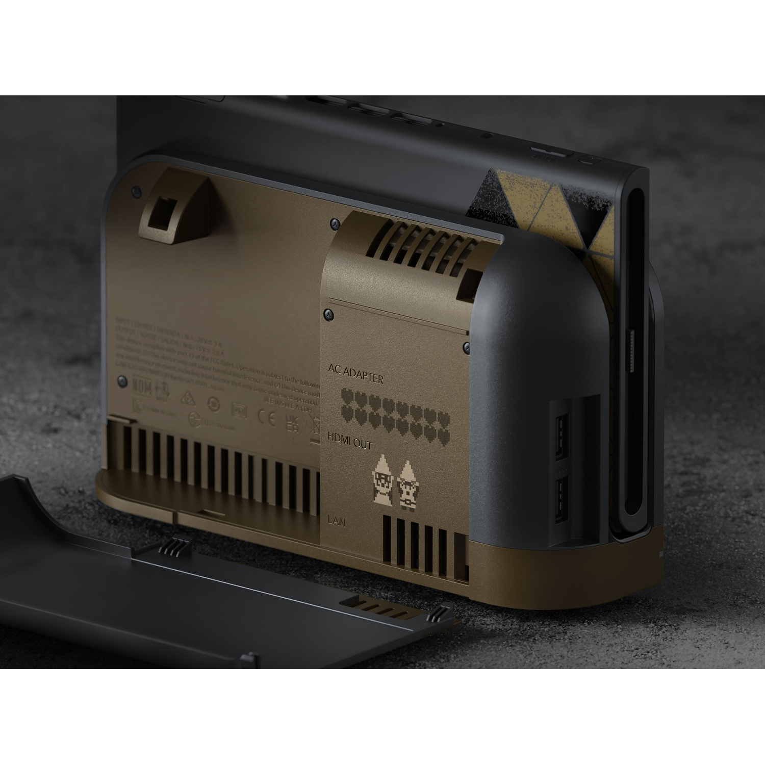 Achterkant van een zwarte en bronzen Nintendo Switch dock met open kabelvak op een donker oppervlak.