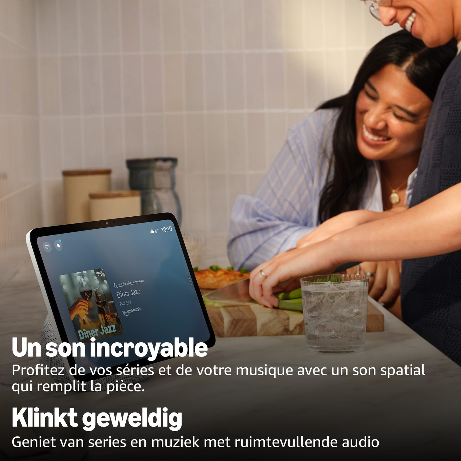 Deux femmes cuisinent dans une cuisine près d'un écran intelligent avec de la musique. Verre de glaçons.