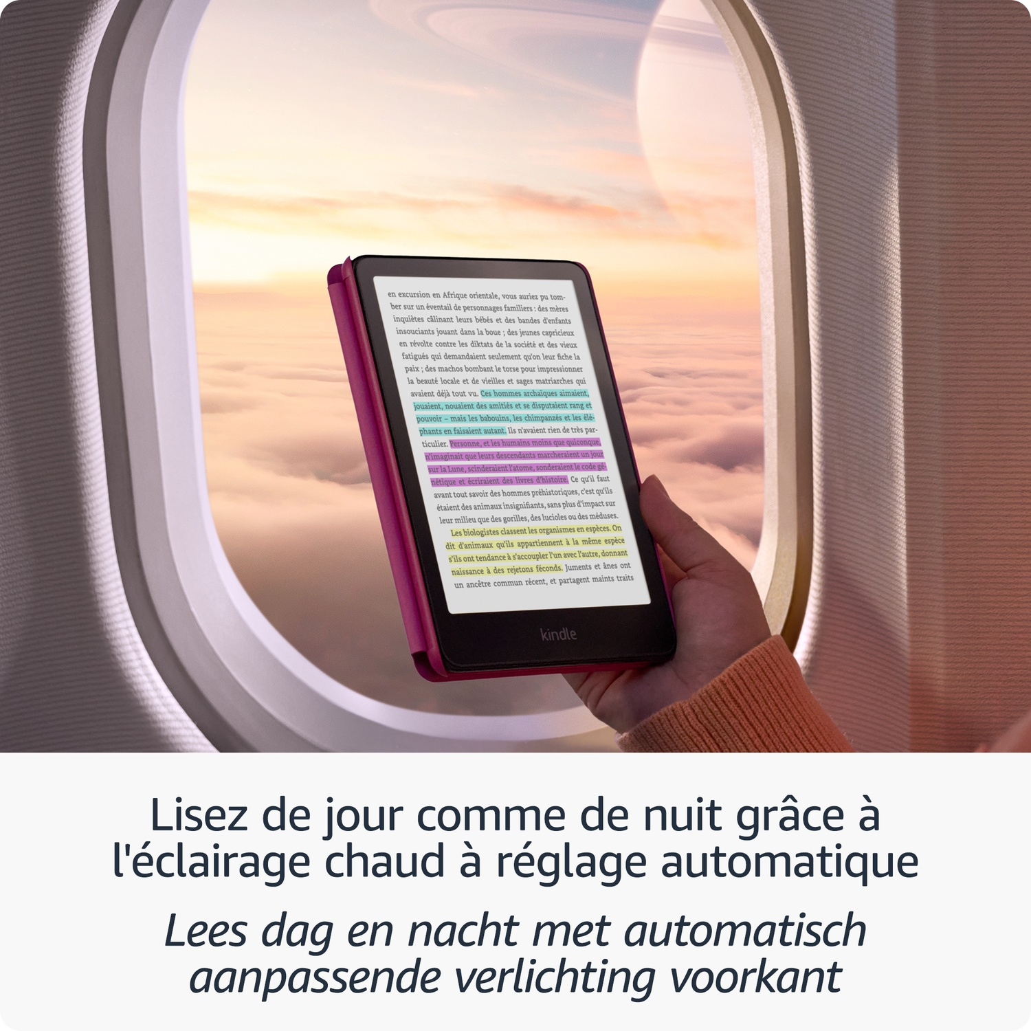Une personne tient une liseuse Kindle avec du texte en couleur devant un hublot d'avion surplombant les nuages.
