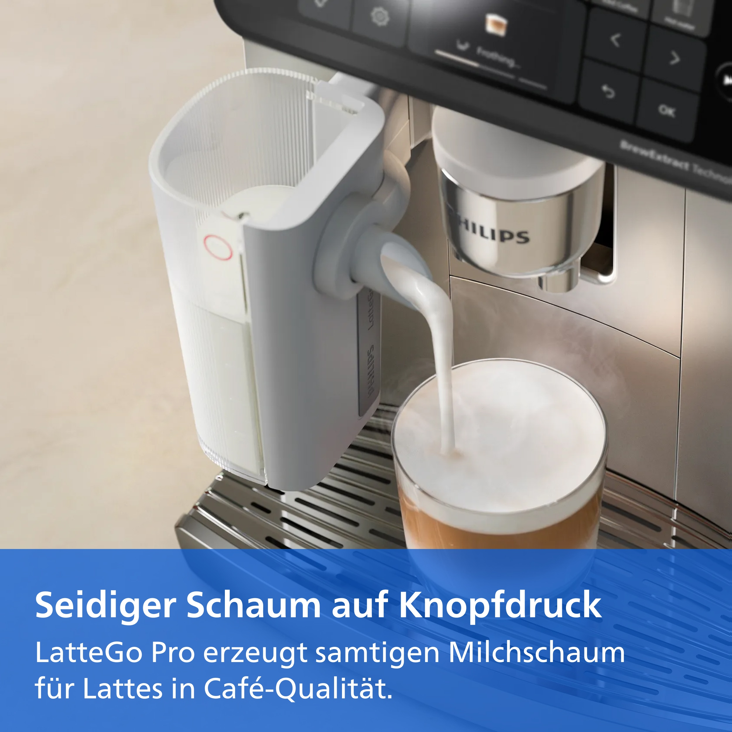 Milchaufschäumer gießt Milch in ein Glas mit Kaffee, mit Text Seidiger Schaum auf Knopfdruck.