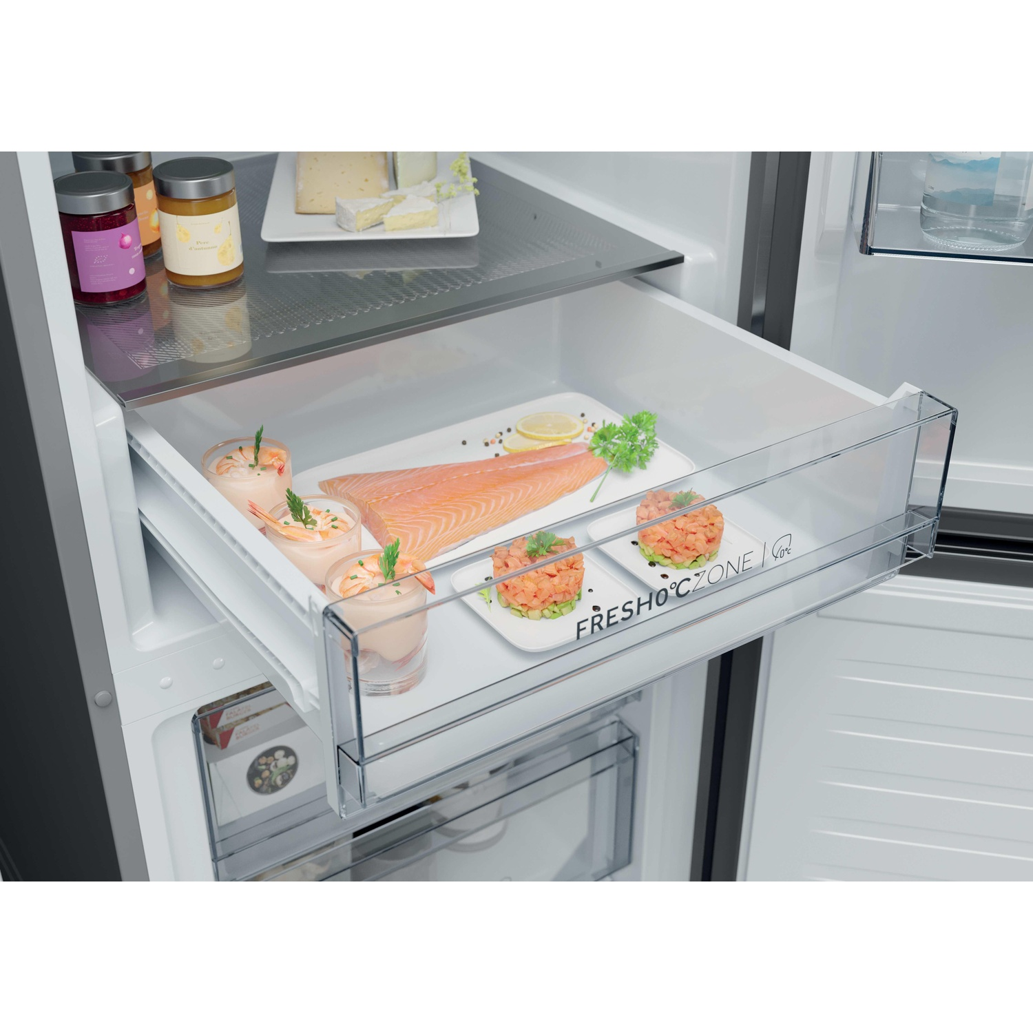Un tiroir de réfrigérateur ouvert contient du poisson frais, des crevettes et des petits plats.