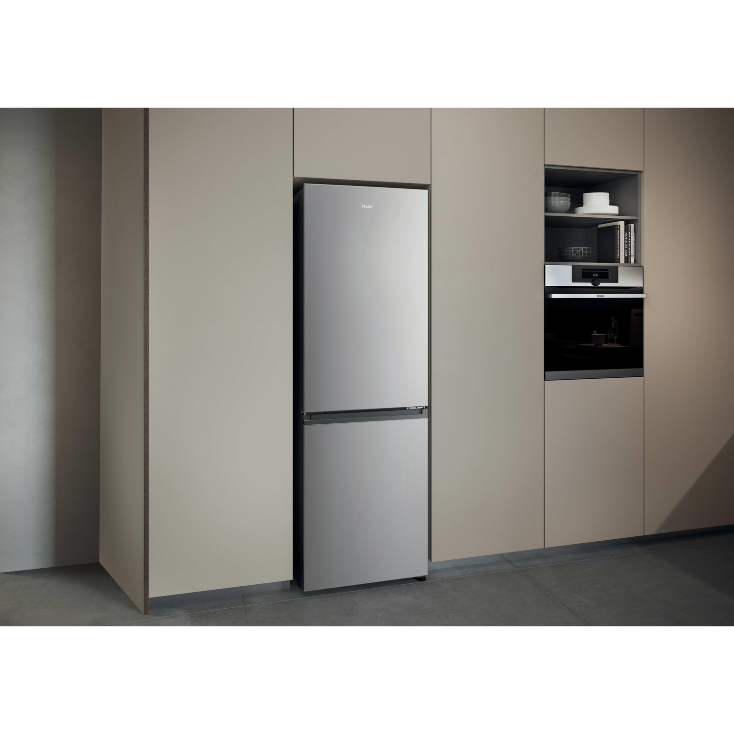 Moderne combiné réfrigérateur-congélateur en acier inoxydable dans une cuisine beige intégrée.
