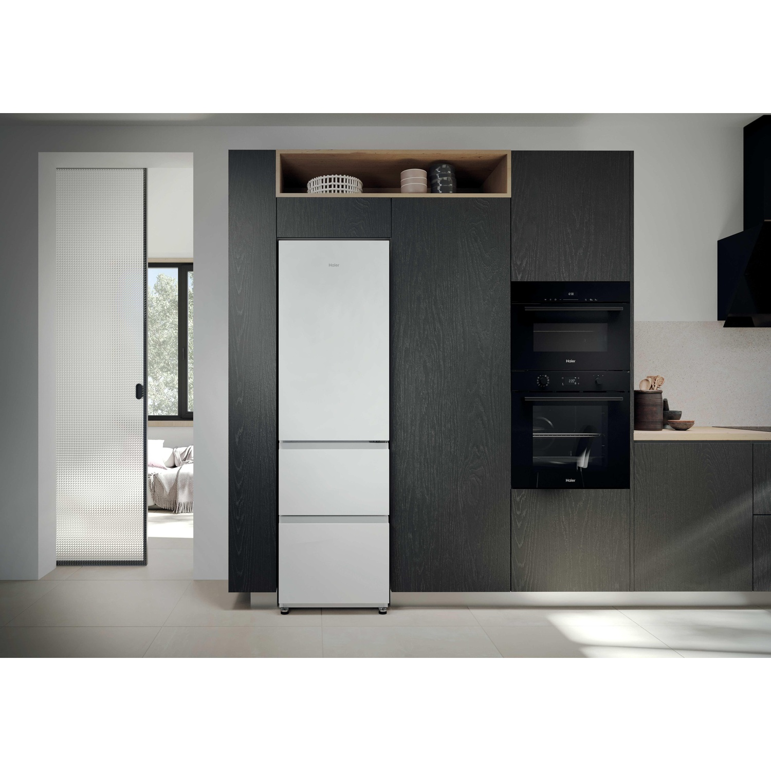 Cuisine moderne avec réfrigérateur blanc Haier, placards sombres et four encastré.