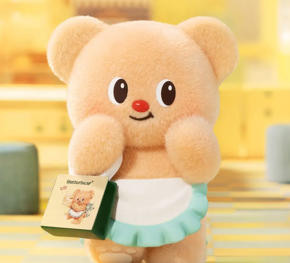 Ein flauschiger gelber Bär mit einer Schürze hält eine kleine Butterbear-Einkaufstasche in einer hellen Küche.