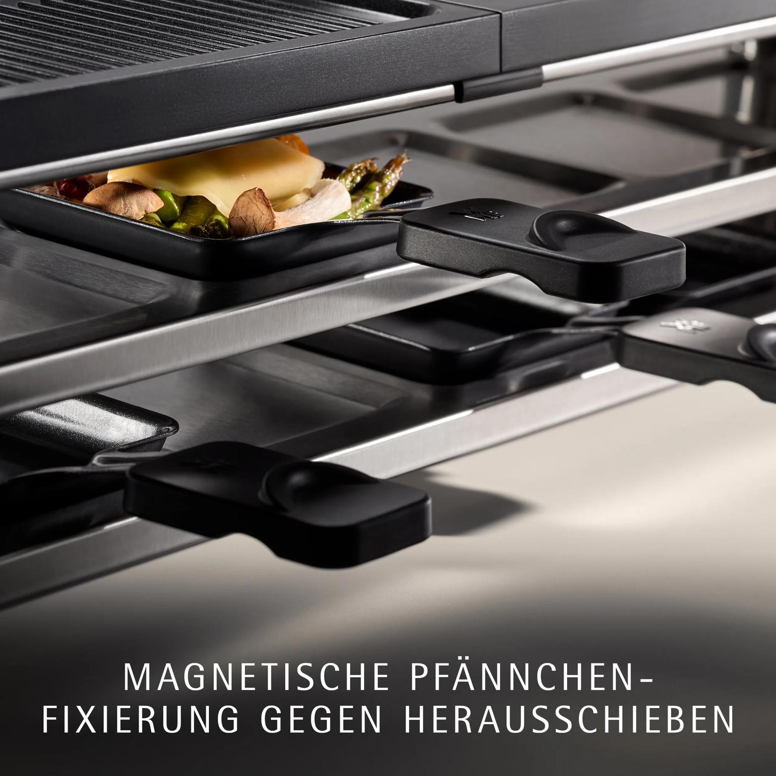 Ein Raclette-Grill mit Pfännchen, gefüllt mit Gemüse und Käse, zeigt eine magnetische Fixierung.