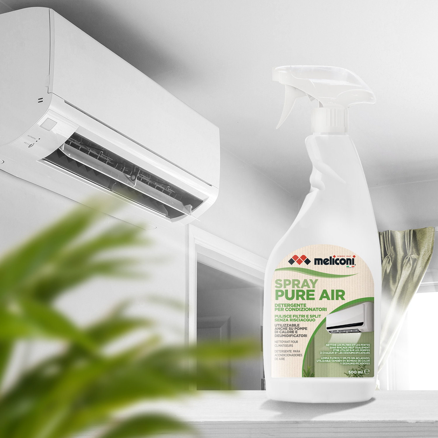 Un flacone spray bianco su un tavolo, con un condizionatore a parete e una pianta verde sullo sfondo.