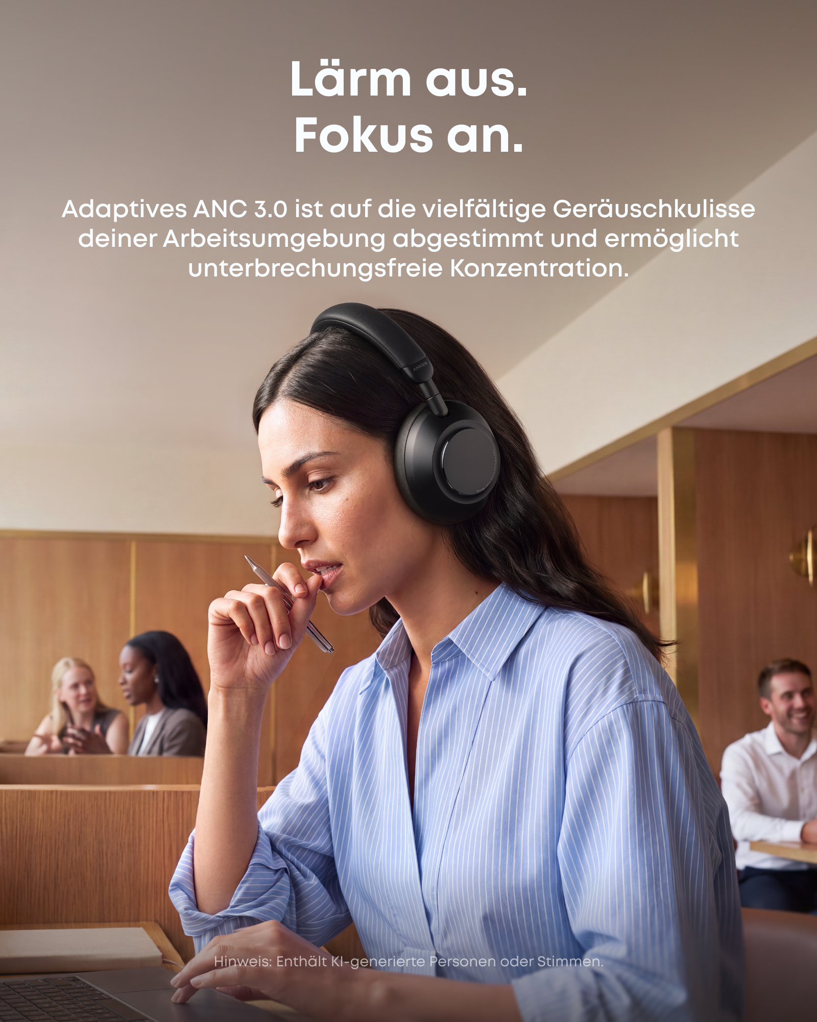 Eine Frau mit schwarzen Kopfhörern sitzt in einem modernen Büro und arbeitet konzentriert an einem Laptop.