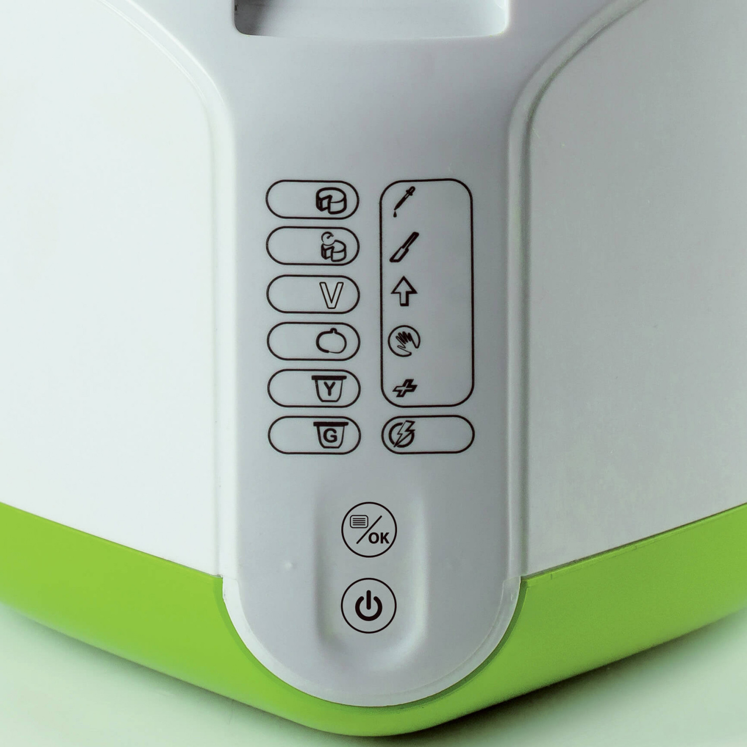 Primo piano dei pannelli di controllo di un dispositivo bianco e verde con varie icone di funzione.