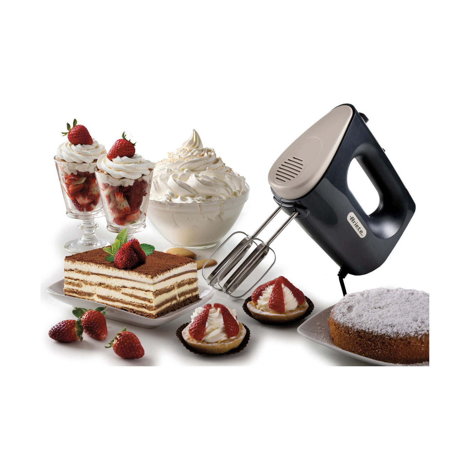 Un mixer a mano nero accanto a dessert, torta e panna montata su sfondo bianco.